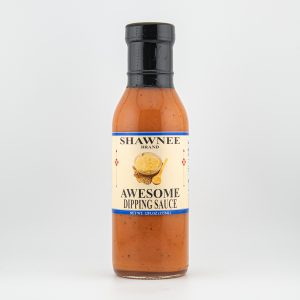 Bottle of Shawnee Brand Awesome Dipping Sauce, featuring an orange sauce with a label showcasing cheese and spoon image, set against a plain background.