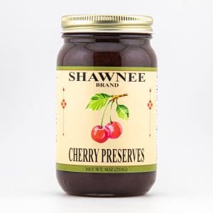 A jar of Shawnee Brand cherry preserves is displayed, featuring an illustration of cherries on the label. The net weight is 9 oz (255g).